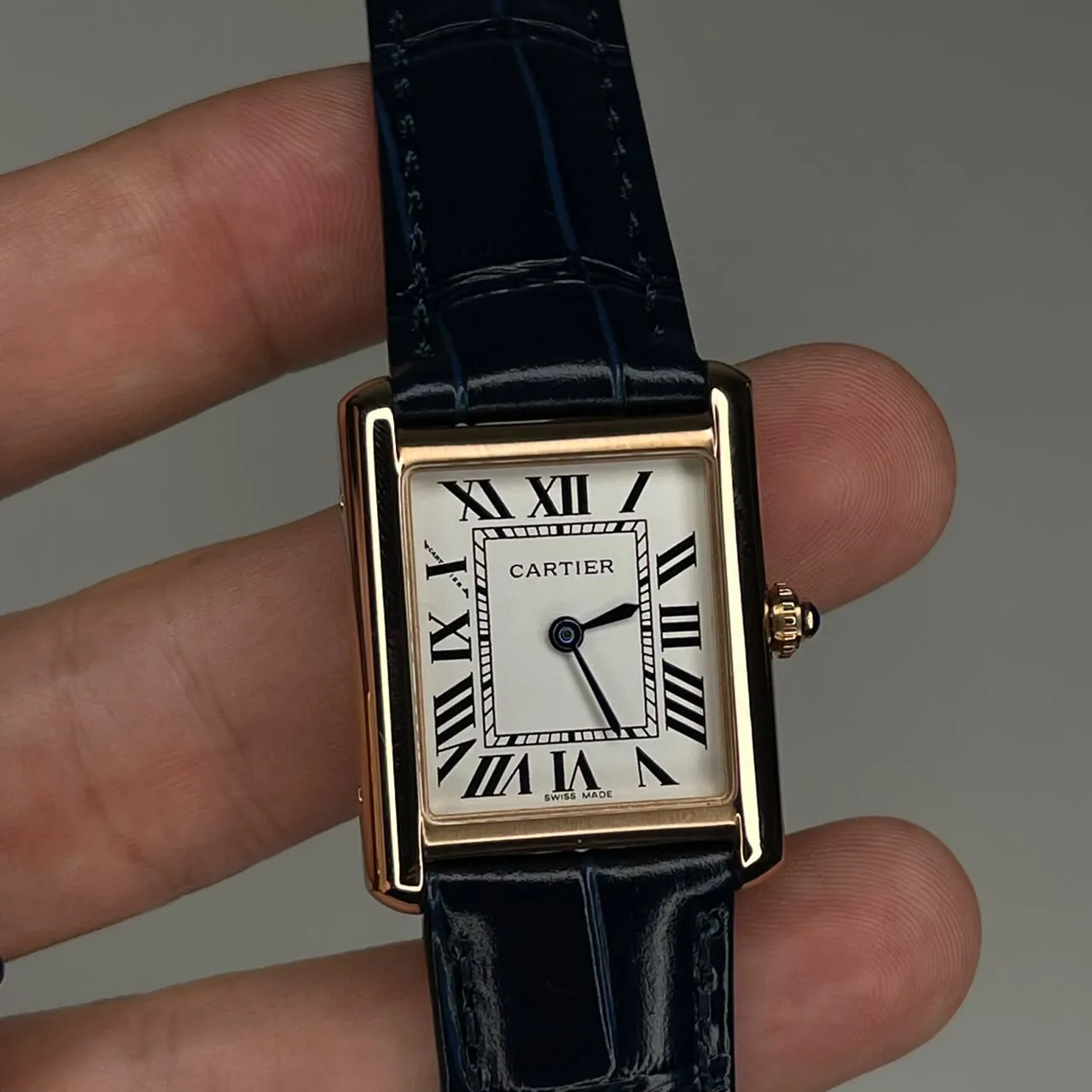 Reloj Cartier de caja cuadrada con correa azul.